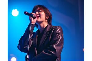 마이크 앞에서 열정적으로 노래하는 팝/록 가수